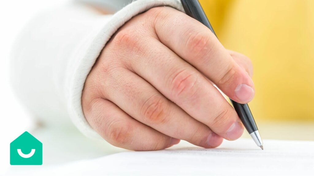 Une main avec un plâtre écrivant avec un stylo noir sur du papier blanc.